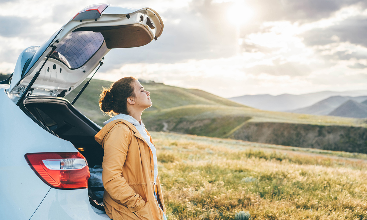 Additional Cover Hero Image. Woman sat outside car